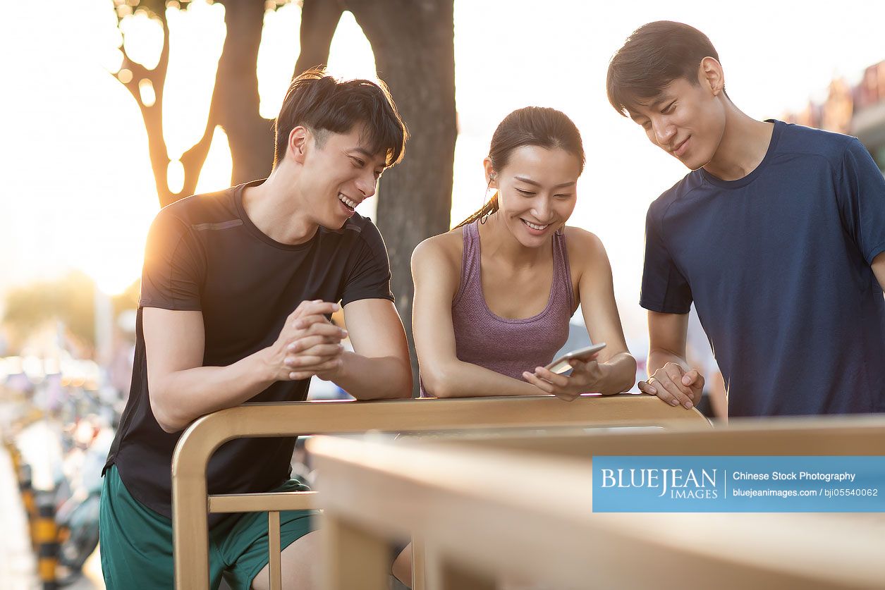 Young Chinese friends resting after exercising