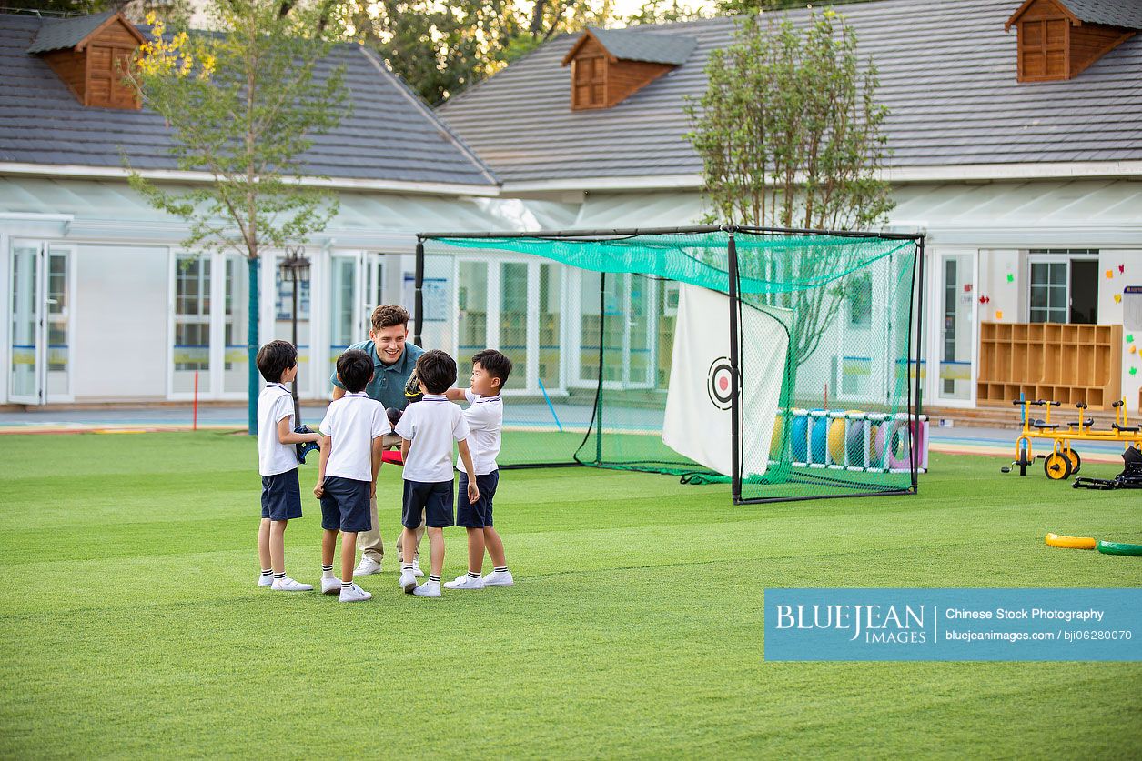 Foreign teacher teaching children basketball