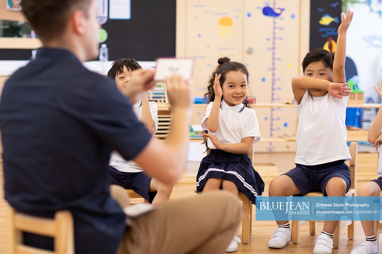 Foreign teacher teaching children English in classroom