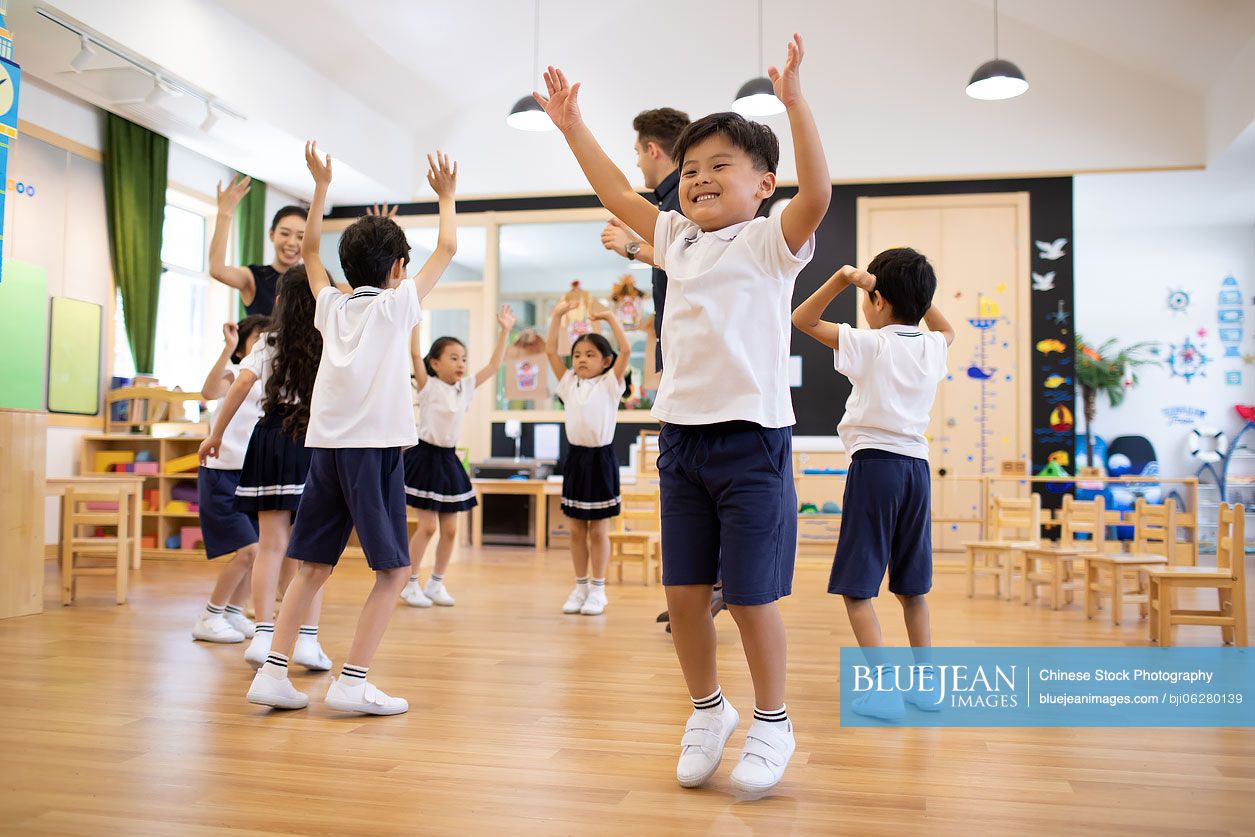 Teachers and children playing in classroom