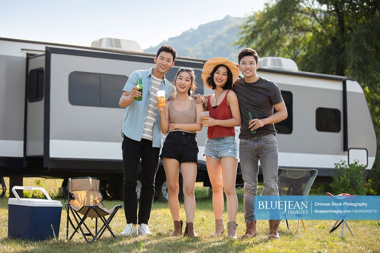 Happy young Chinese friends having a picnic outdoors