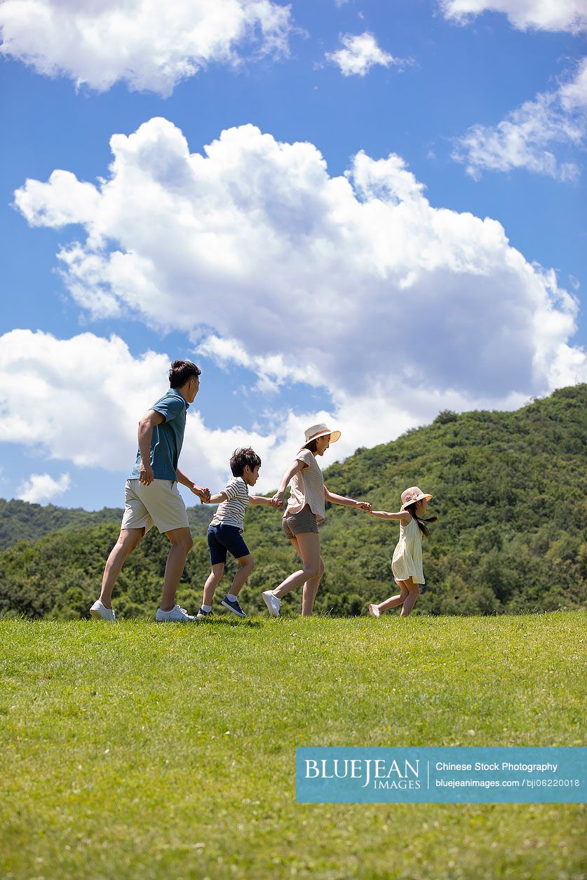 Happy young Chinese family having fun outdoors