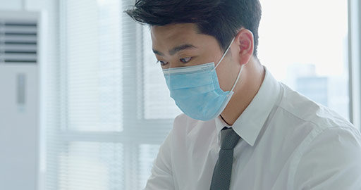 Young Chinese businessman with surgical mask working in office,4K