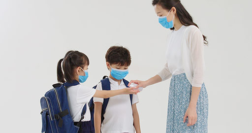 Chinese pupils using hand sanitizer with teacher's help,4K