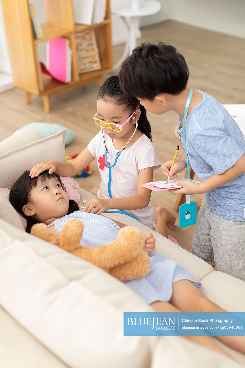 Cute Chinese girl playing doctor in living room-High-res stock photo for  download