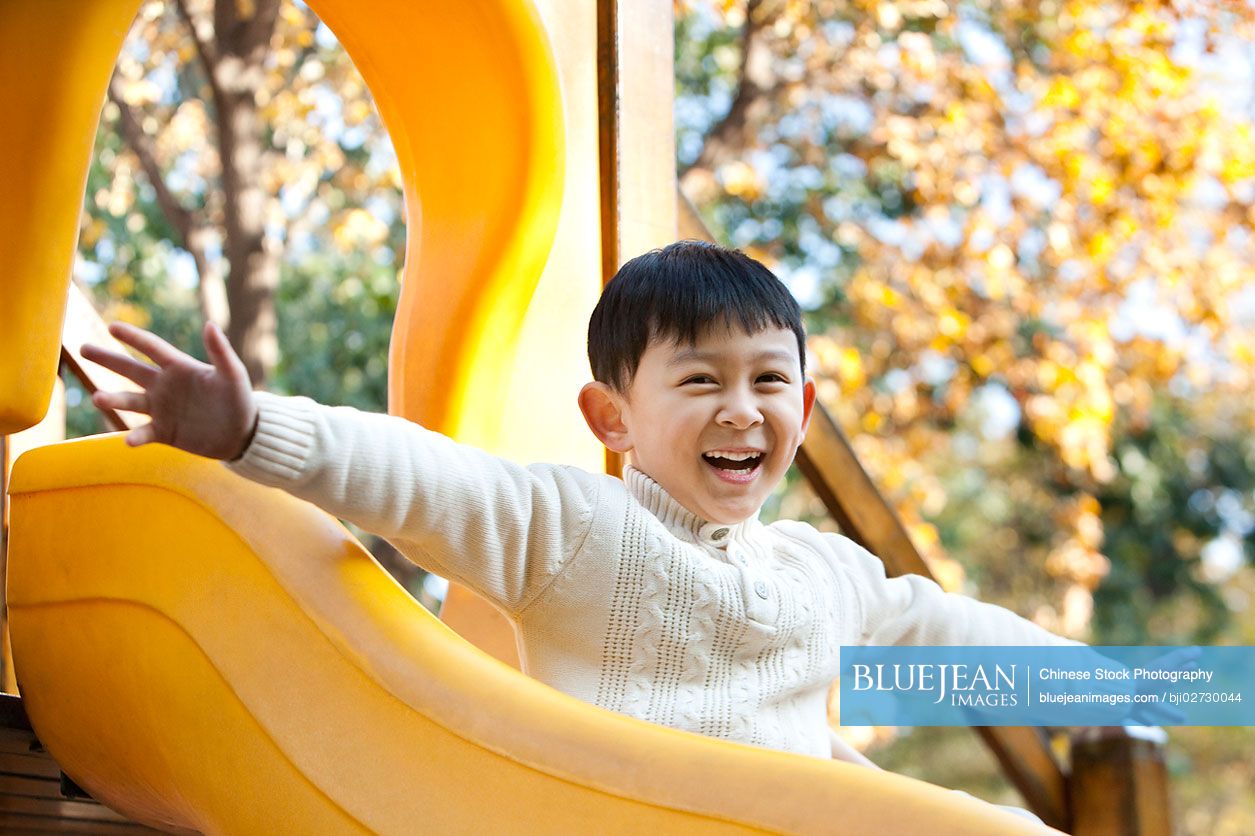 chinese-boy-playing-on-playground-slide-high-res-stock-photo-for-download