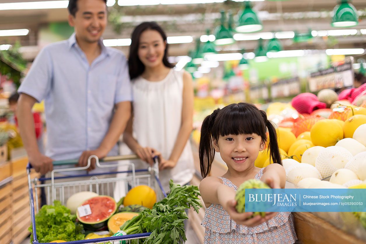 Happy young Chinese family shopping in supermarket