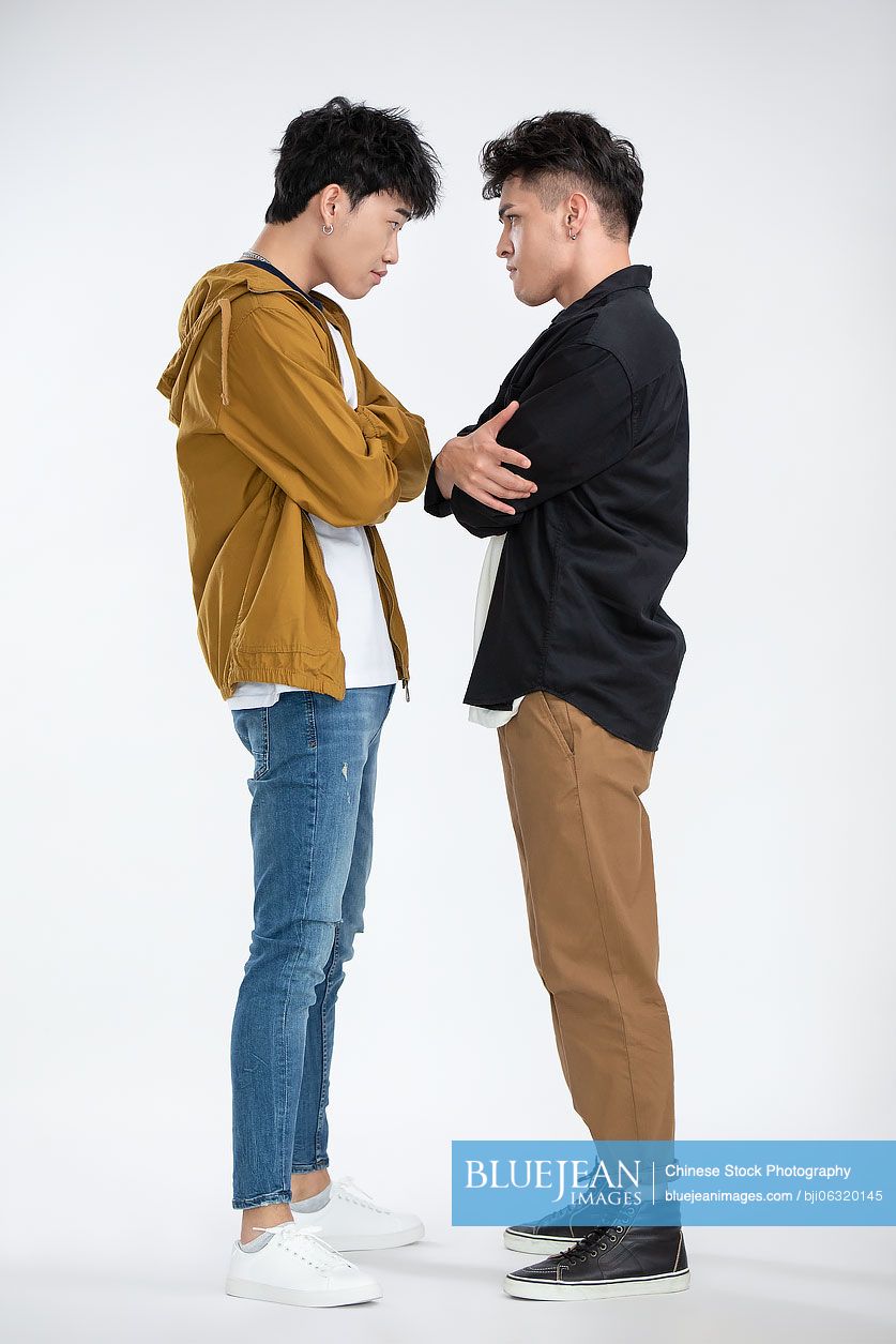 Young Chinese men standing face to face