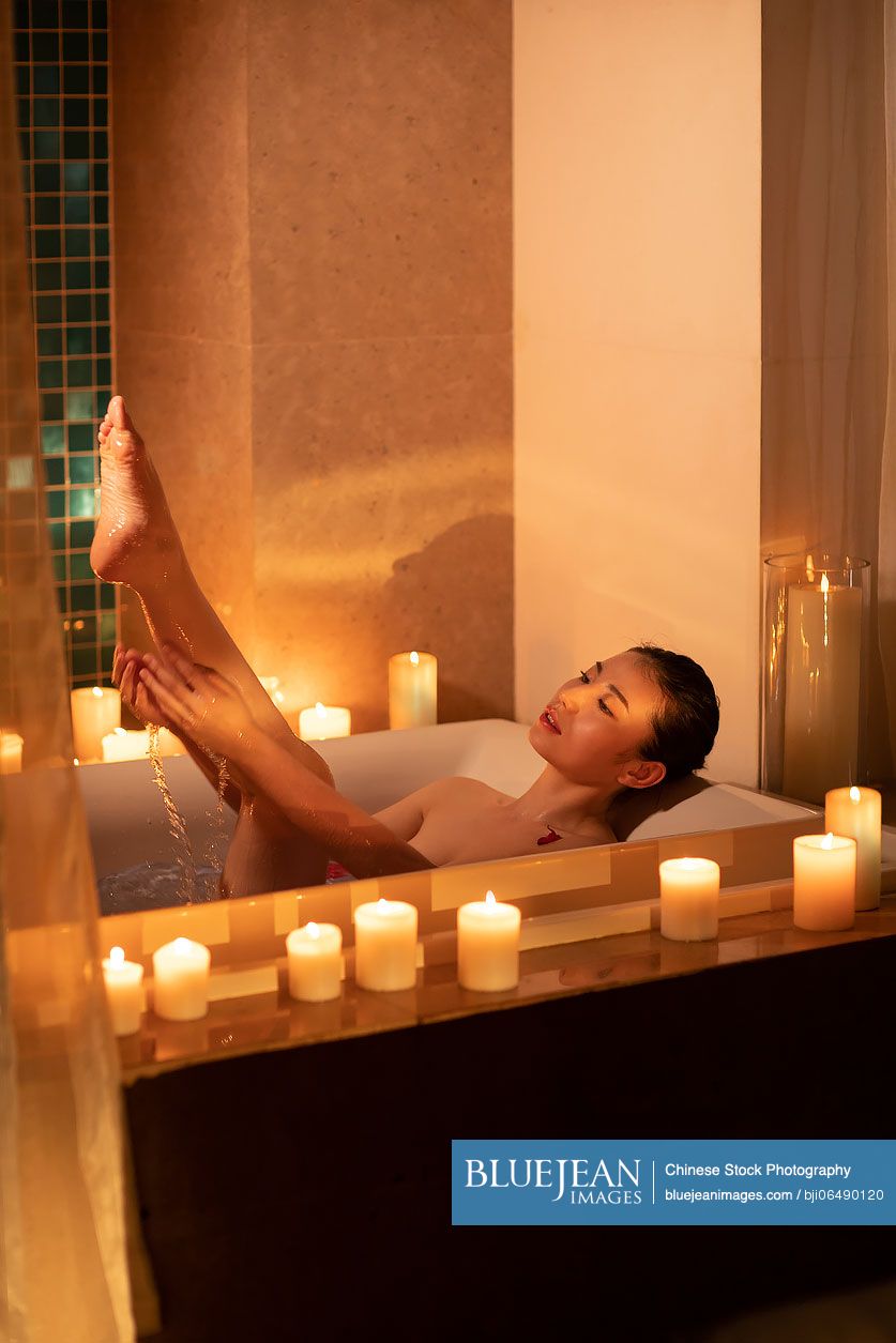 Beautiful young Chinese woman relaxing in bathtub