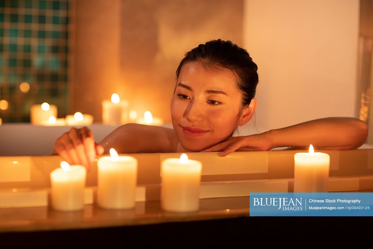 Beautiful young Chinese woman relaxing in bathtub