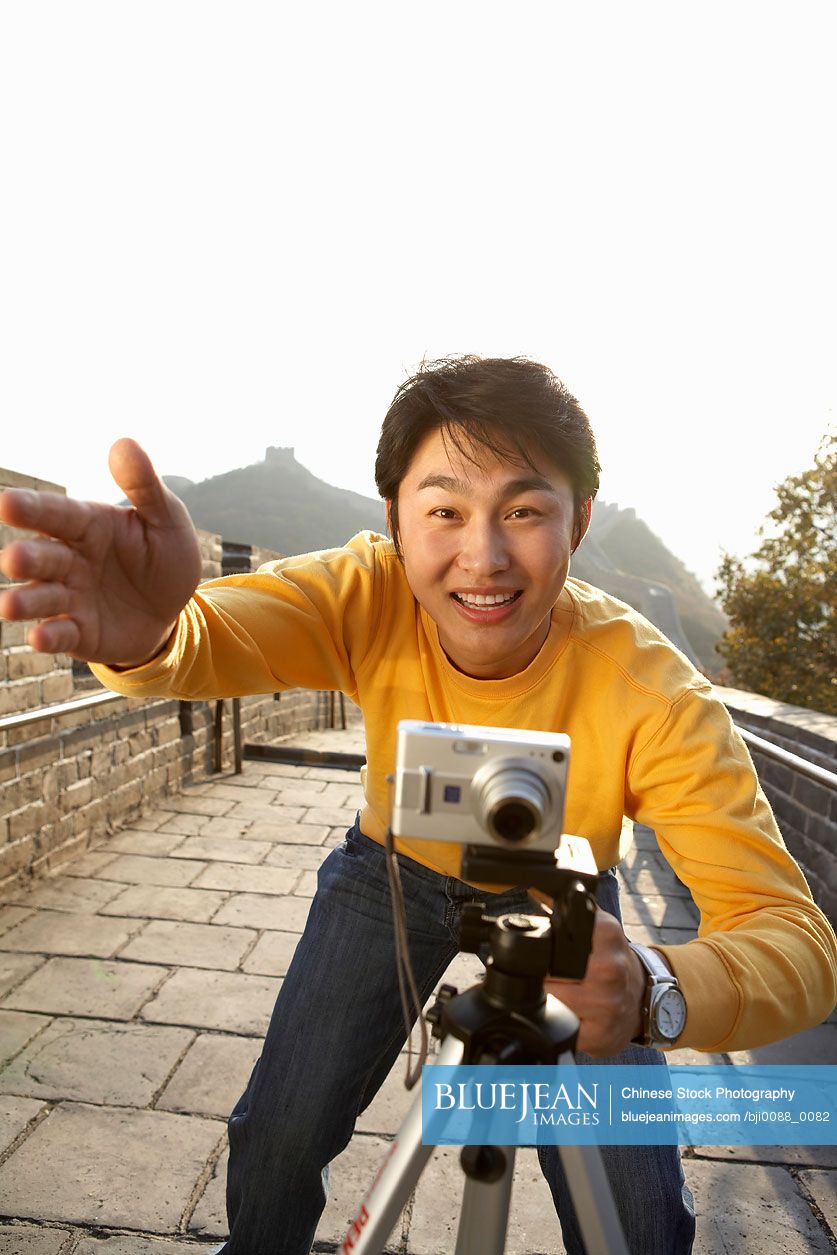 Young Chinese man sets up a photo on the Great Wall of China