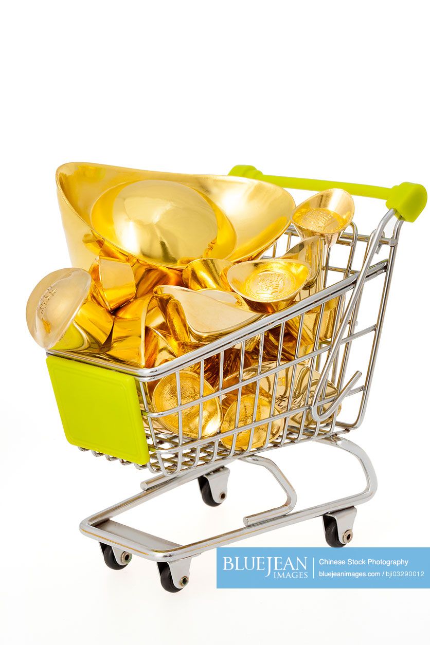 Chinese traditional currency gold yuanbao ingots in a small shopping cart