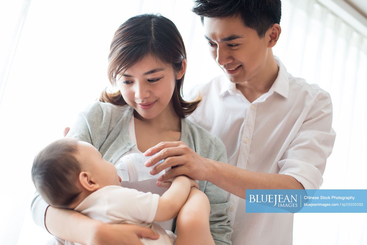 Young Chinese parents feeding baby