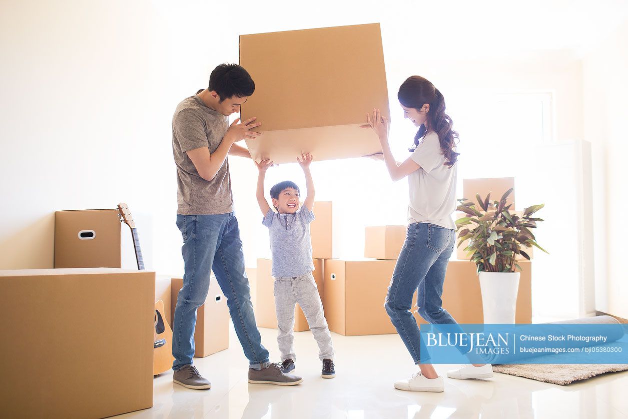 Happy young Chinese family moving to a new house