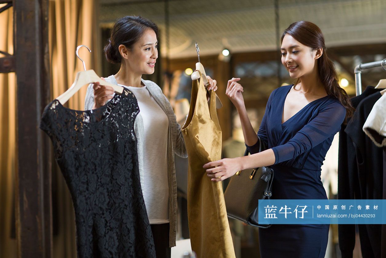 服装店主帮助顾客挑选衣服
