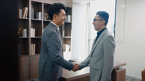 Successful Chinese business people shaking hands in office