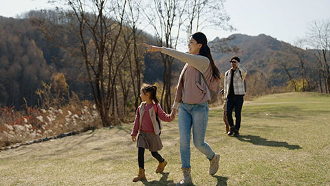 Happy young Chinese family hiking outdoors