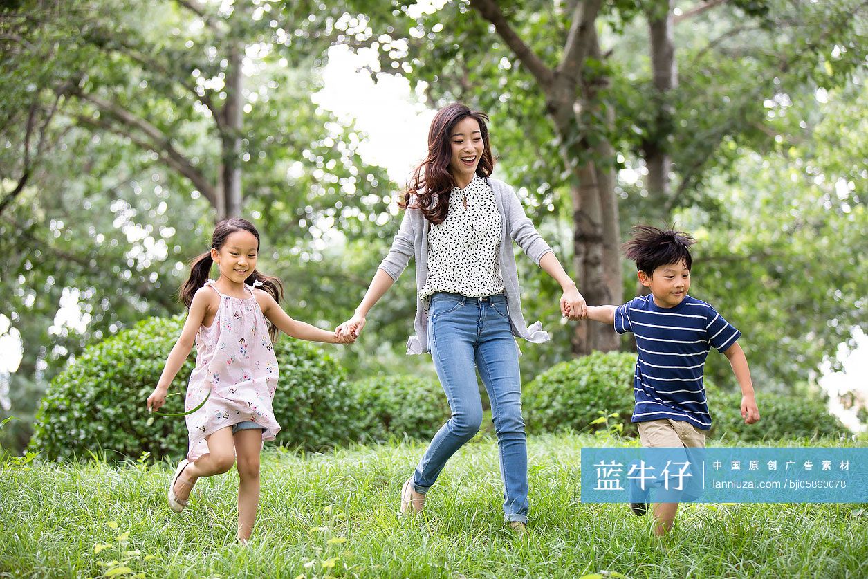 快乐的年轻家庭在草地上奔跑