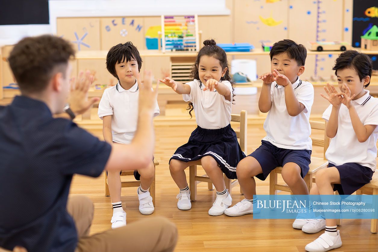 Foreign teacher and children playing games in classroom