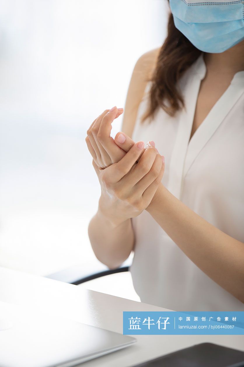 年轻的商务女士在办公室使用免洗洗手液