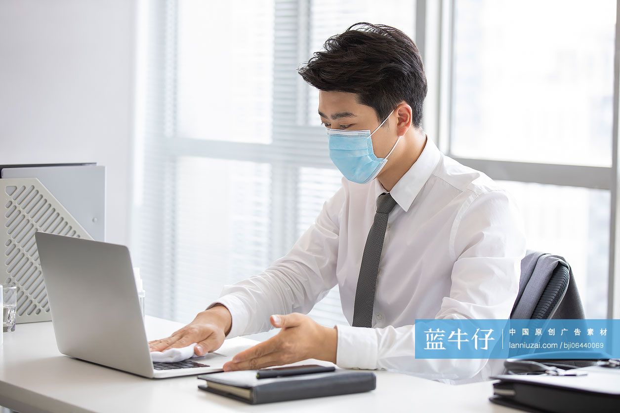 年轻的商务男士在办公室使用消毒液杀菌消毒