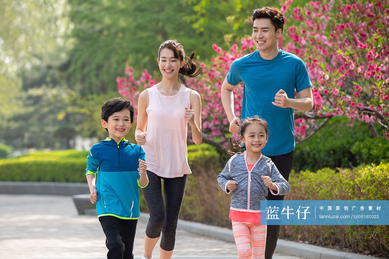 快乐的年轻家庭在公园跑步