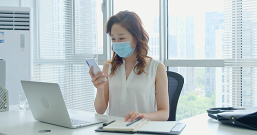Young Chinese businesswoman with surgical mask working in office,4K