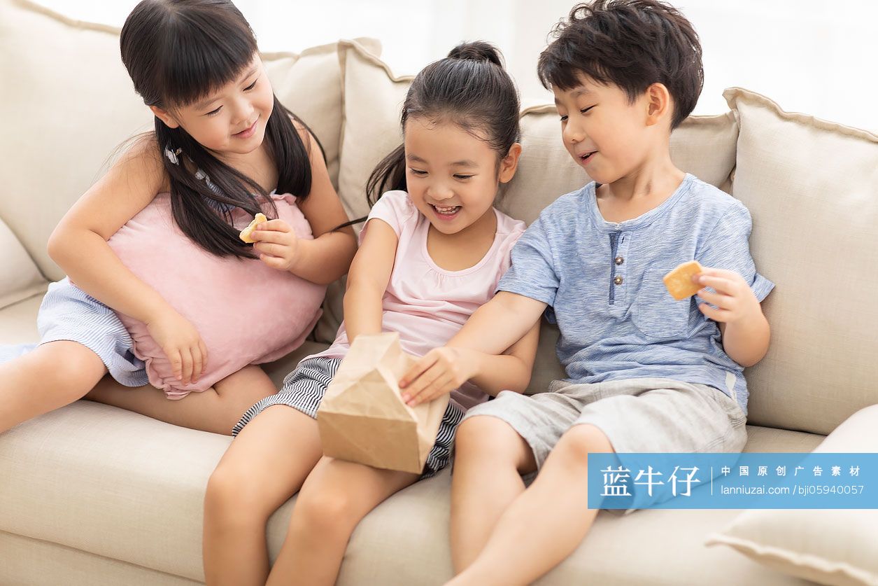 三个小朋友在沙发上吃饼干