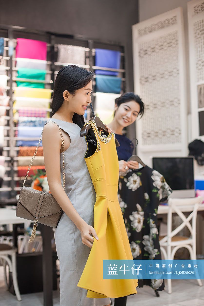 服装店店主帮助顾客挑选衣服