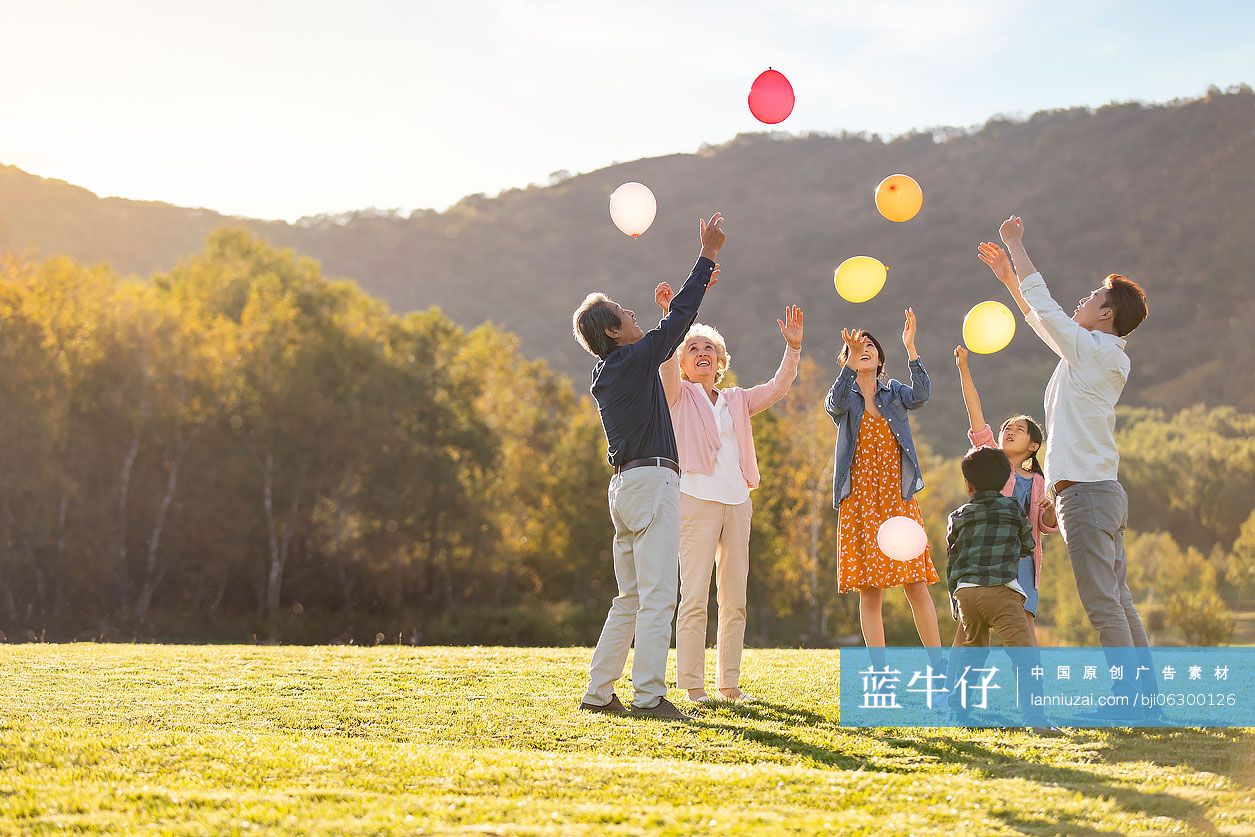 快乐的的六口之家在草地上玩气球