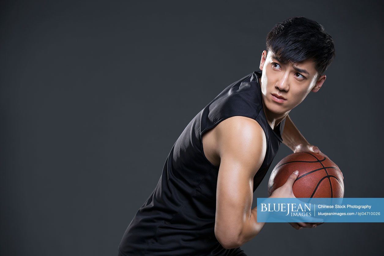 Young Chinese man playing basketball