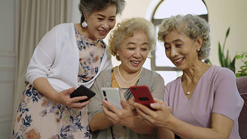Happy senior Chinese friends using smart phones at home,4K