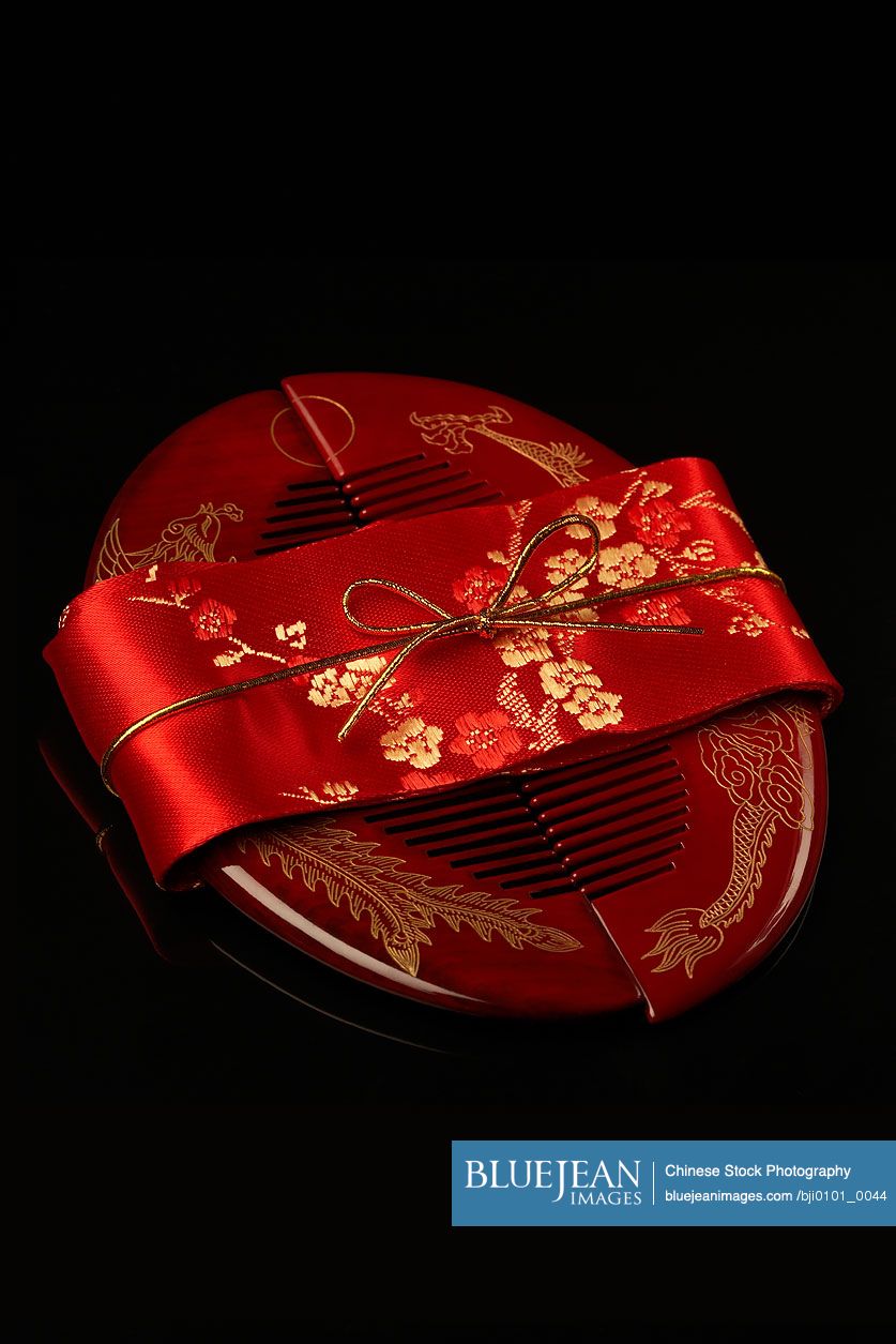 A set of red Chinese hair combs wrapped in a red ribbon