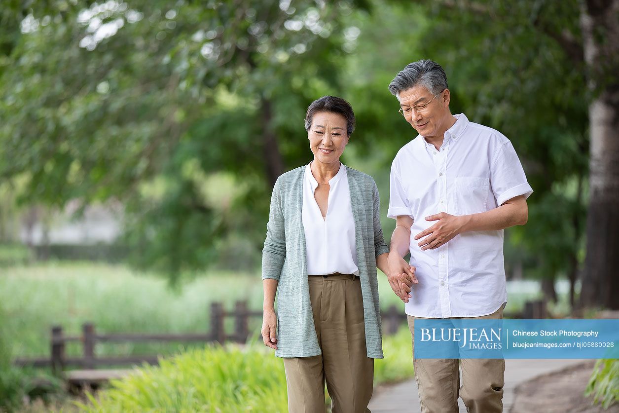 Happy senior Chinese couple walking in park-High-res stock photo for  download