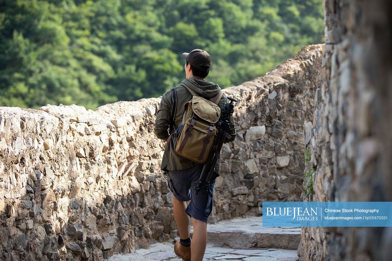 Chinese Photographer walking in village