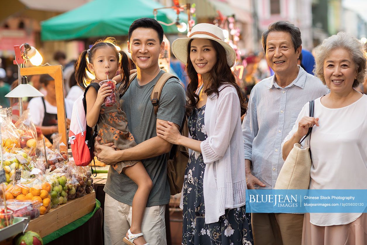 Happy Chinese family relaxing in street market