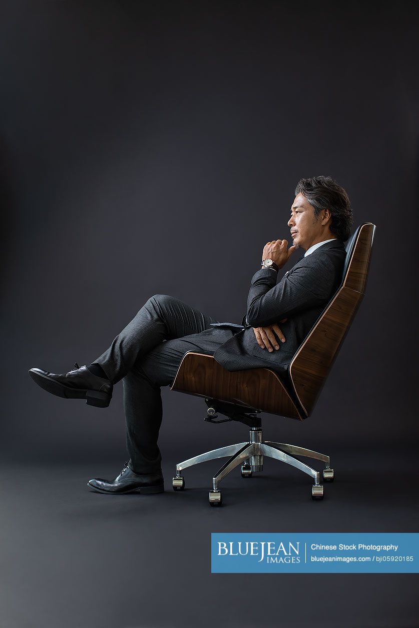 Confident Chinese businessman sitting on chair