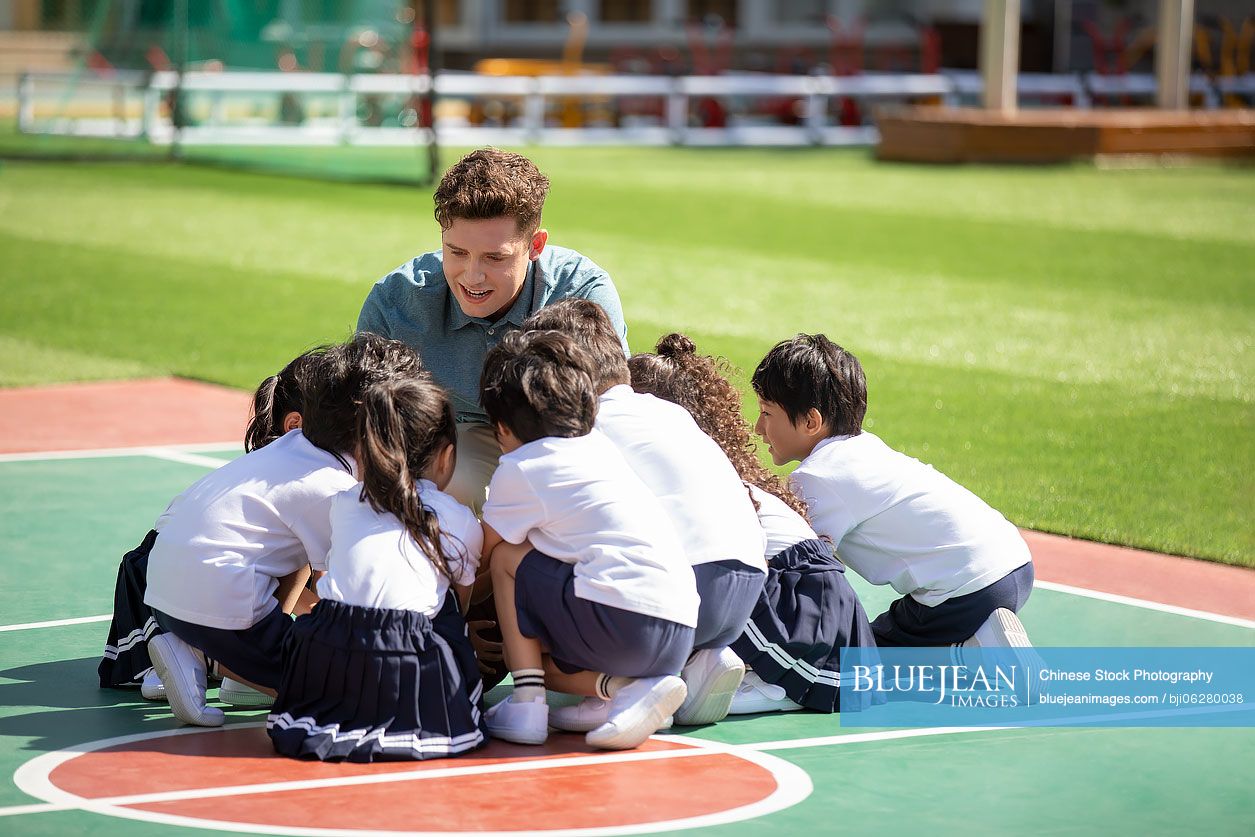 Foreign teacher and children playing in playground