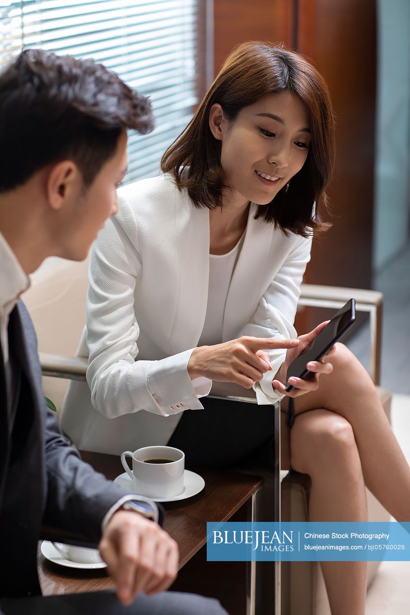 Chinese business people using smartphone in office