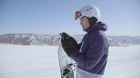 Young Chinese man using smart phone on the snow,4K