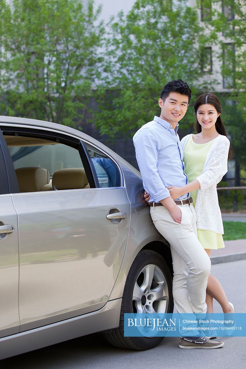Happy young Chinese couple and car