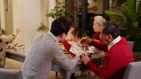A son gifting his father a fine bottle of spirits to celebrate Chinese New Year