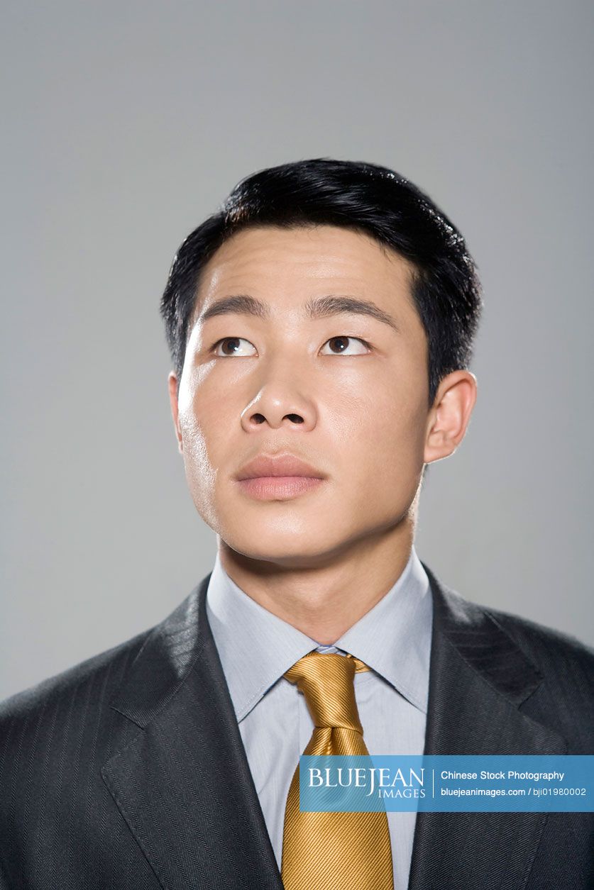 Chinese businessman using hands to greet on grey background