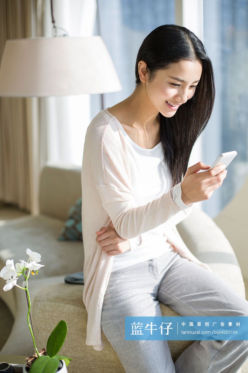 快乐的年轻女子使用手机