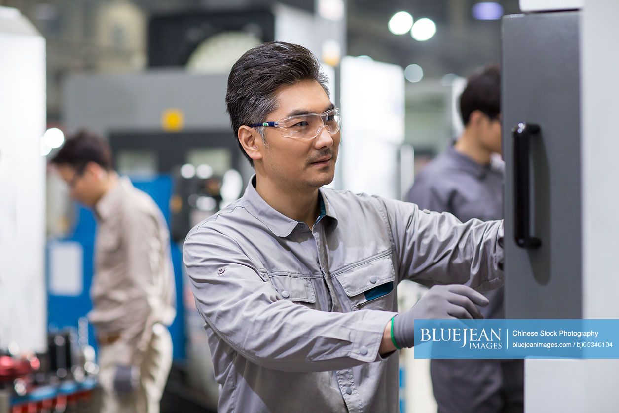 Confident Chinese engineers working in the factory