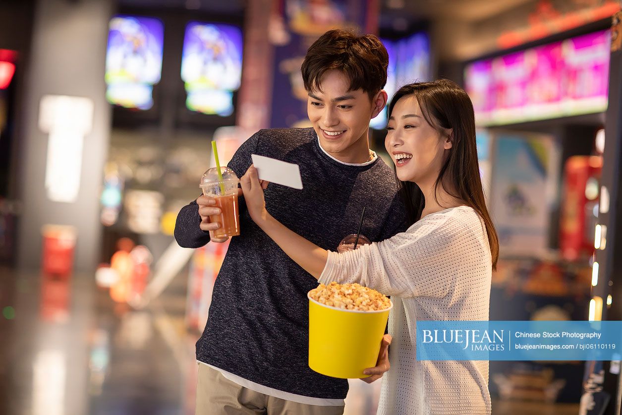 Happy young Chinese couple dating in shopping mall