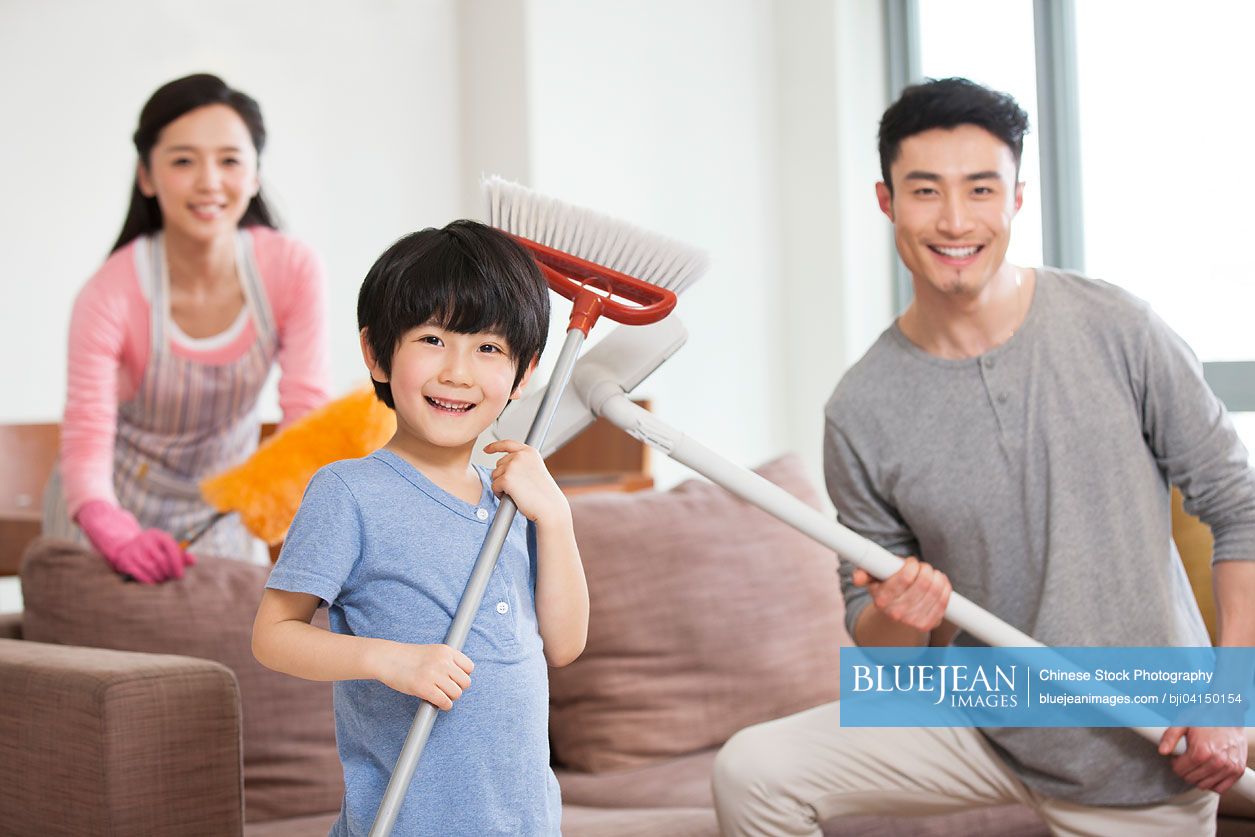 Cheerful Chinese family doing chores at home