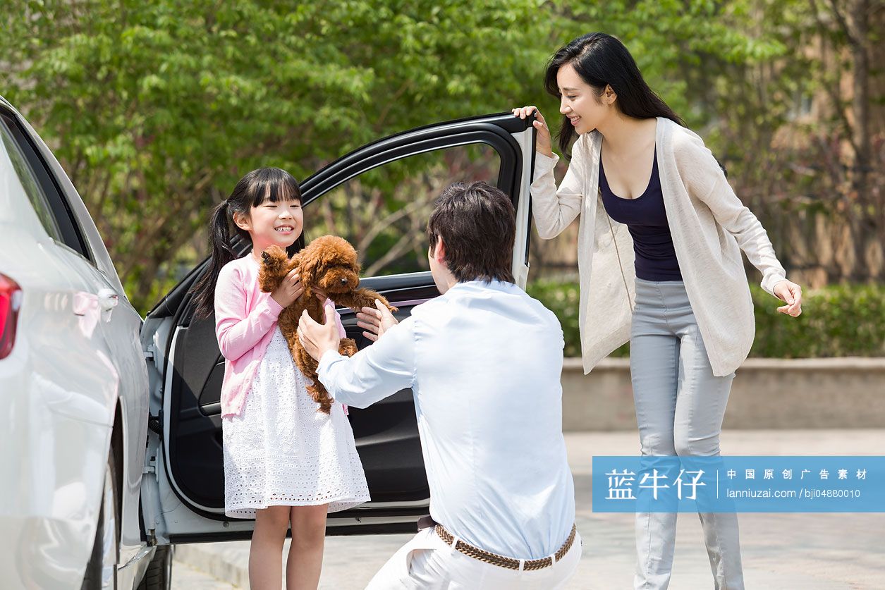 年轻的三口之家带着宠物狗下车