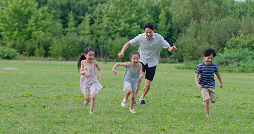 快乐年轻家庭在草地上玩耍