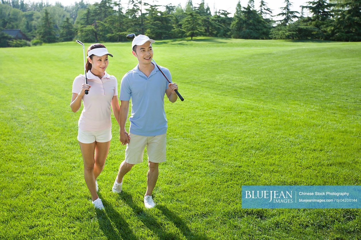 Young Chinese couple going to play golf